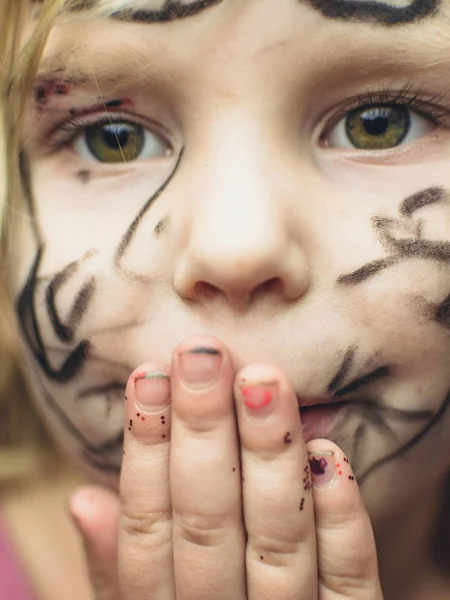 Het kleine meisje haar gezicht geschilderd met een marker. Make-up voor Halloween. — Stockfoto