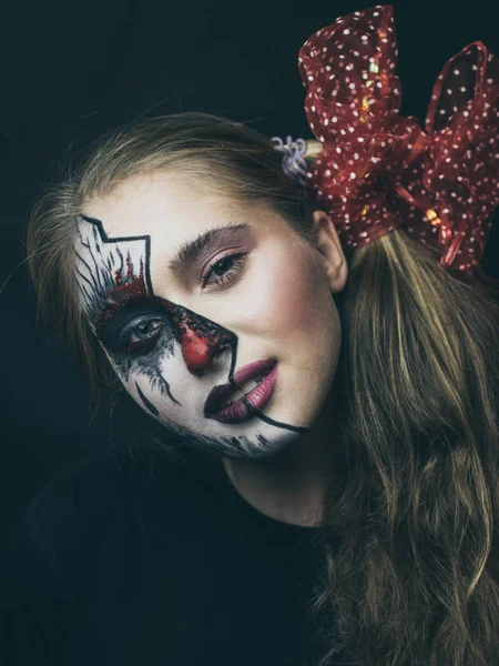 Halloween, la cara de una chica es una muñeca, el suelo de una cara está muerto. Una mujer con un maquillaje horrible . — Foto de Stock