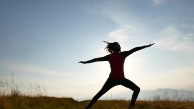 Bir adam dreadlocks ile Şafakta yoga yapıyor. Dağlar Karpatlar, Ukrayna