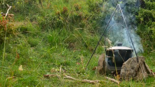 Cozinhar comida ao ar livre em panela turística na fogueira. Processo de preparação de alimentos de acampamento em fogo ardente enquanto caminhadas para a natureza selvagem — Vídeo de Stock