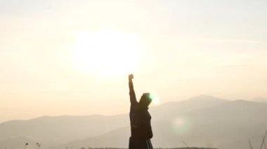 Bir turist dreadlocks ile dağın zirvesine gitti. Şafakta çekim. Sevinç ve kendi üzerinde zafer