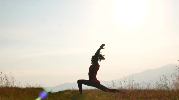 En man med dreadlocks gör yoga i gryningen. Bergen i Karpaterna, Ukraina — Stockvideo