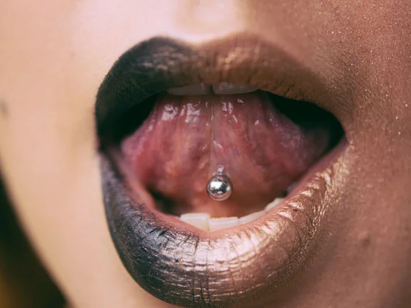 Gros plan des lèvres et des piercings dans la langue. Concept tendance . — Photo