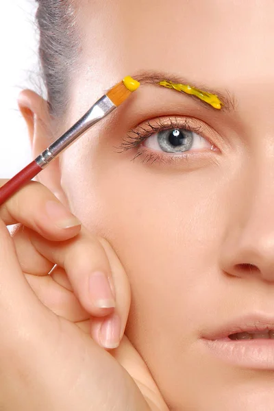 Young woman putting some special effects makeup on face — Stock Photo, Image