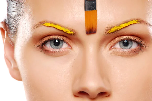 Молодая женщина наносит макияж спецэффектов на лицо — стоковое фото