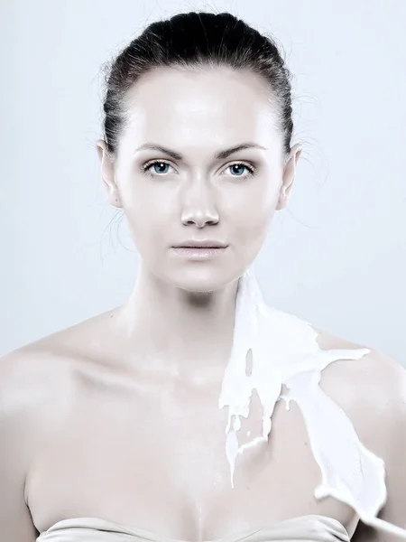 Portret van een jonge vrouw met druppels melk op haar — Stockfoto