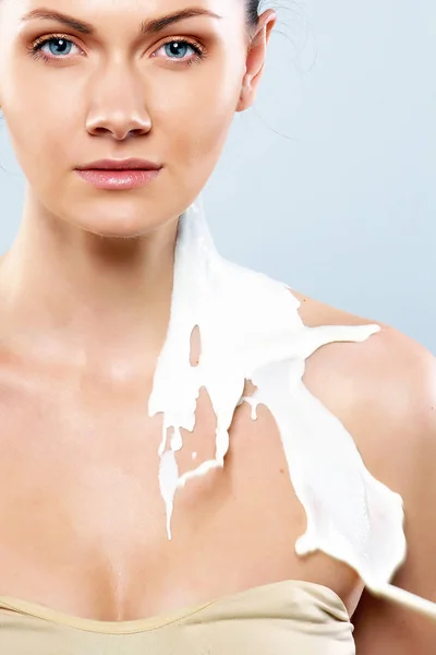 Portret van een jonge vrouw met druppels melk op haar — Stockfoto