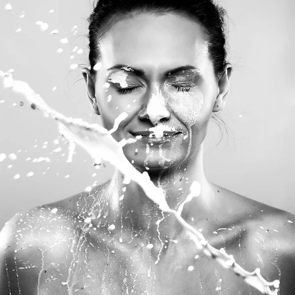 Portret młodej kobiety z kropli mleka na jej — Zdjęcie stockowe