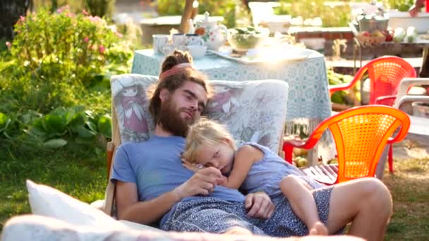 Pappa och dotter vilar i friska luften. Sommarkväll i byn. — Stockvideo