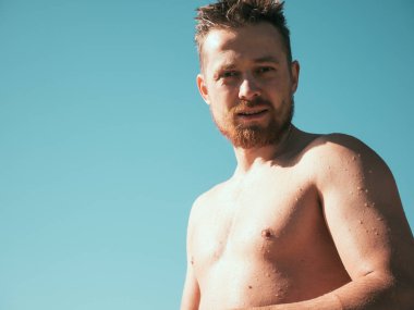 kaslı adam kas gövde güneşli günde mavi gökyüzü arka plan, yaz tatili, kopya alanı ile