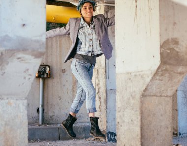 Şehrin modern bir kadın. Hipster beton yapılar arka plan üzerinde