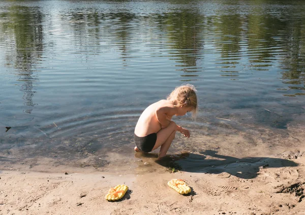 Una niña de pie en la orilla del río . — Foto de Stock