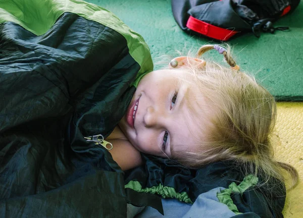 En fyra-åriga flicka ligger inne en turist-tältet. Morgon på campingen — Stockfoto