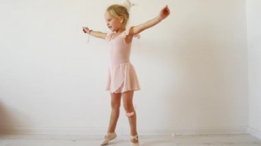 Küçük balerin beyaz bir arka plan üzerinde dans