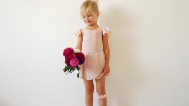 Young dancer posing with a bouquet of flowers. Happy little ballerina. — Stock Video