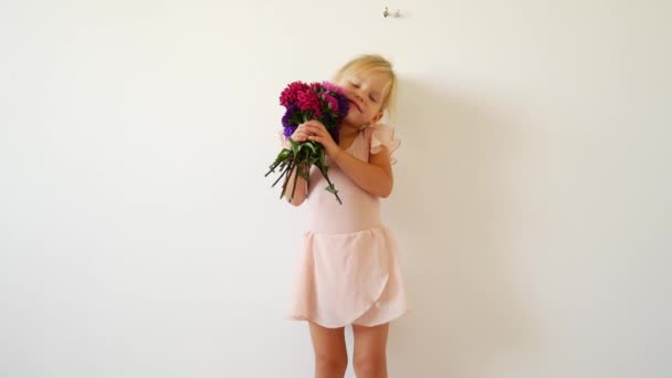 Молодая танцовщица позирует с букетом цветов. Счастливая маленькая балерина . — стоковое видео