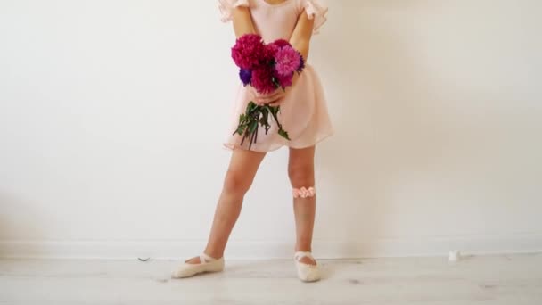 Young dancer posing with a bouquet of flowers. Happy little ballerina. — Stock Video