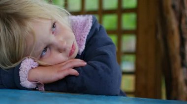 Küçük kız çardak içinde ağlıyor. Sonbahar yağmurlu bir gün