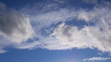 Farklı yönlere bulutlar float. güneşli gün mavi gökyüzü