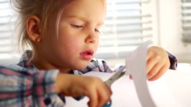 Küçük kız ustalıkla makasla kontrol.