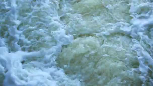 Ruscelli d'acqua sulla diga del fiume schizzano fuori dalla porta e formano onde. Primo piano — Video Stock