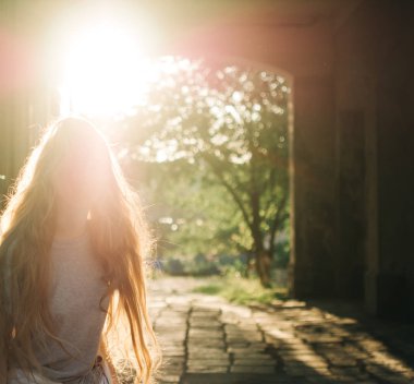 Günbatımı ışınlarının Kızıl saçlı Genç kız. Şehir portre