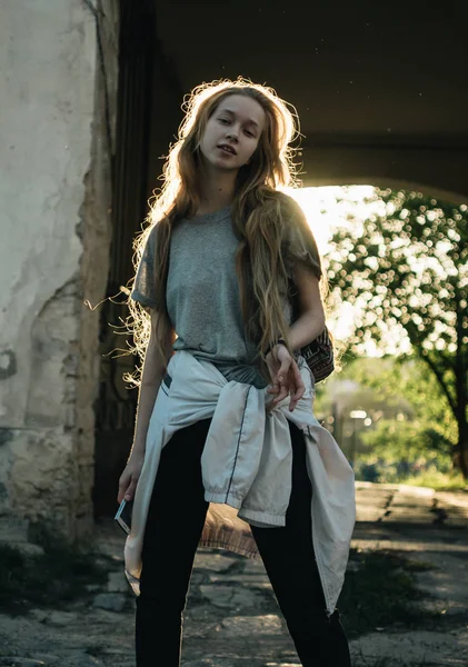 Teen girl si trova nell'arco al tramonto. Silhouette di una ragazza con i capelli lunghi — Foto Stock