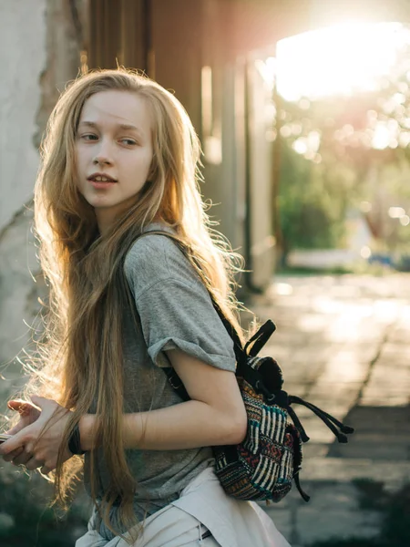 Rusovlasá mladá dívka v paprscích zapadajícího slunce. Portrét města — Stock fotografie