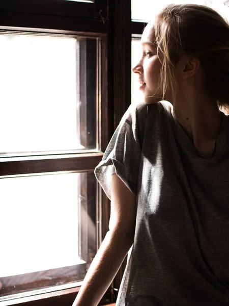 Mooie meisje in de buurt van het venster. Lichte afbeelding. — Stockfoto