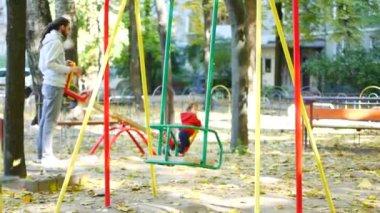 çocuklar için oyun alanı üzerinde küçük bebek ile genç mutlu aile