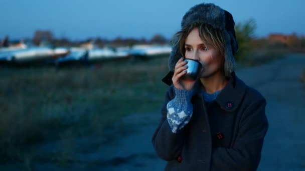 Carino giovane donna europea beve caffè sulla spiaggia al tramonto — Video Stock