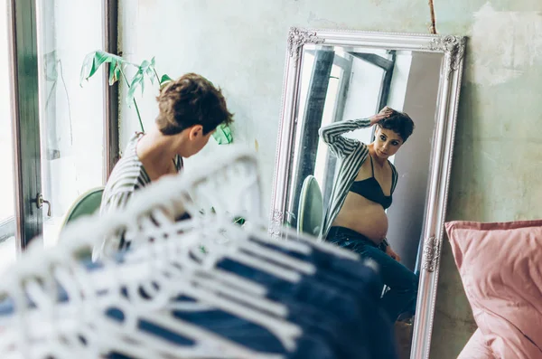 Compras, moda, roupas, estilo e conceito de gravidez - mulher feliz tentando casaco no shopping ou loja de roupas — Fotografia de Stock