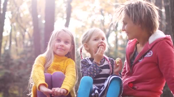 Мама с девочками на пикнике в осеннем лесу — стоковое видео
