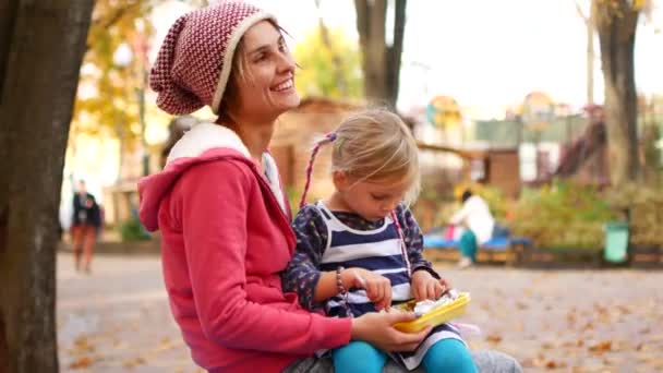 Moeder en dochter lunchen in het park op een herfst middag. Liefde, familie, eten — Stockvideo