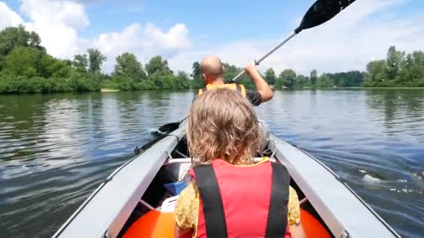 父亲和女儿独木舟在平静的河流。家庭乐趣和积极的运动。慢动作 — 图库视频影像