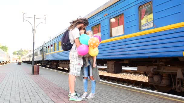 A família reuniu-se na estação. Dreda pais com uma filha e balões — Vídeo de Stock