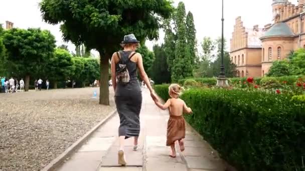 Máma s dcerou pěší ulice starého města. — Stock video