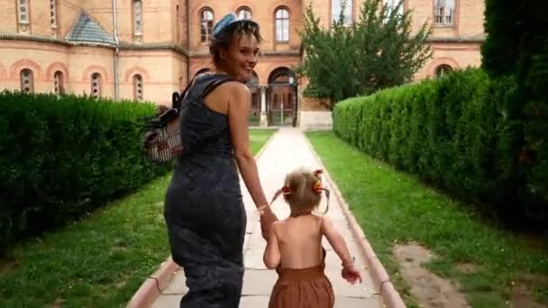 Máma s dcerou pěší ulice starého města. — Stock video