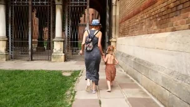 Mom with her daughter walking by old town street. — Stock Video