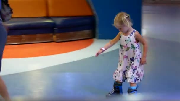 Mor og datter rider på rulleskøjter. Pige lære at rulle skøjter, og falder . – Stock-video