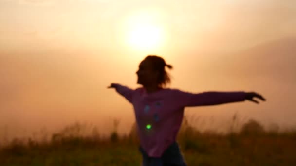 En ung kvinna snurrar vid soluppgången i bergen. — Stockvideo