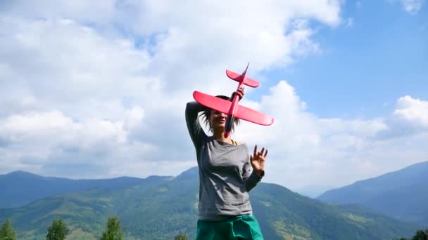 Hipster vacker flicka. Hon slingrar runt själv med en leksak flygplan i handen. — Stockvideo