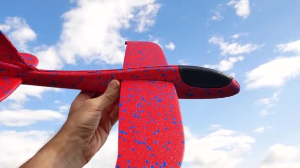 La main lance l'avion sur le fond d'un ciel bleu — Video
