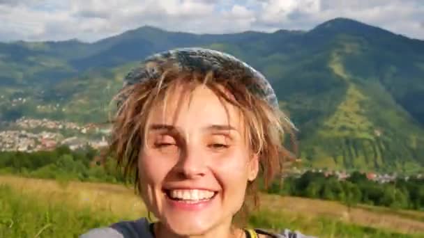 Mladá žena je volání někoho na telefonu a ukazuje hory za ní — Stock video