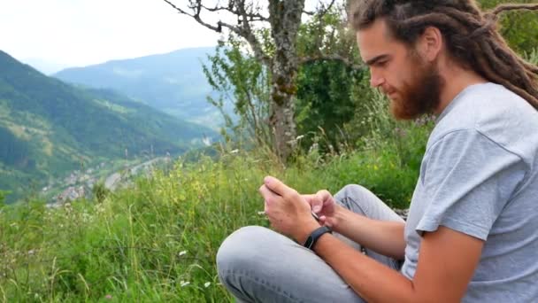 Retrato de un joven usando un teléfono inteligente disfrutando de mensajes de texto enviando mensajes de texto en línea compartiendo comunicación sonriendo feliz tecnología móvil cámara lenta — Vídeos de Stock