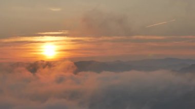 Parlak Zirvesi şafak akan bulut dalgalar, kırmızı güneş disk üzerinde