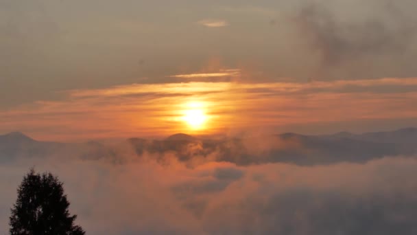 Brillante amanecer cumbre por encima de las olas de nubes que fluyen, disco de sol rojo — Vídeos de Stock