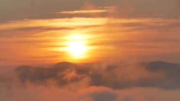 Brillante amanecer cumbre por encima de las olas de nubes que fluyen, disco de sol rojo — Vídeos de Stock