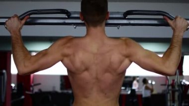 Spor salonunda, kaslı kollarını salıncak kılıyor