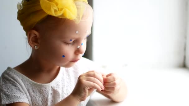 A beautiful little girl at the mirror makes herself a make-up — Stock Video